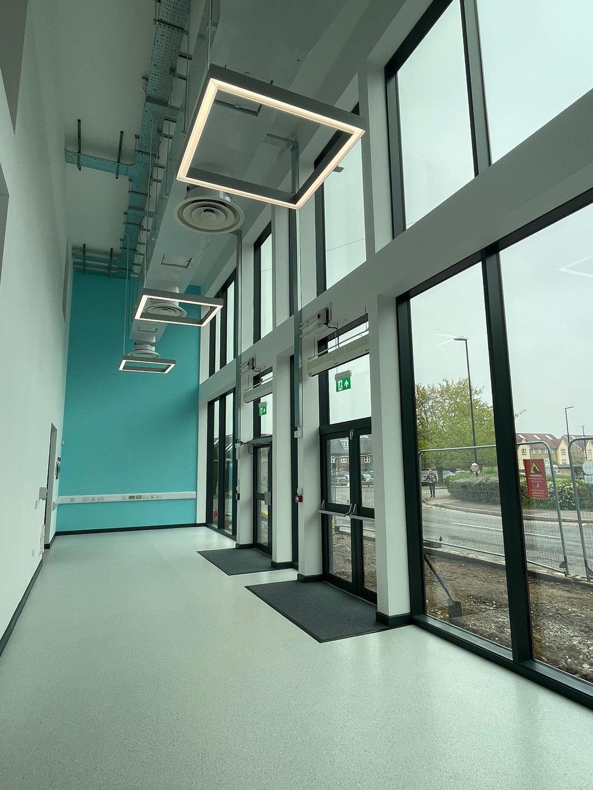 Completed glazed education corridor with coordinated lighting and services